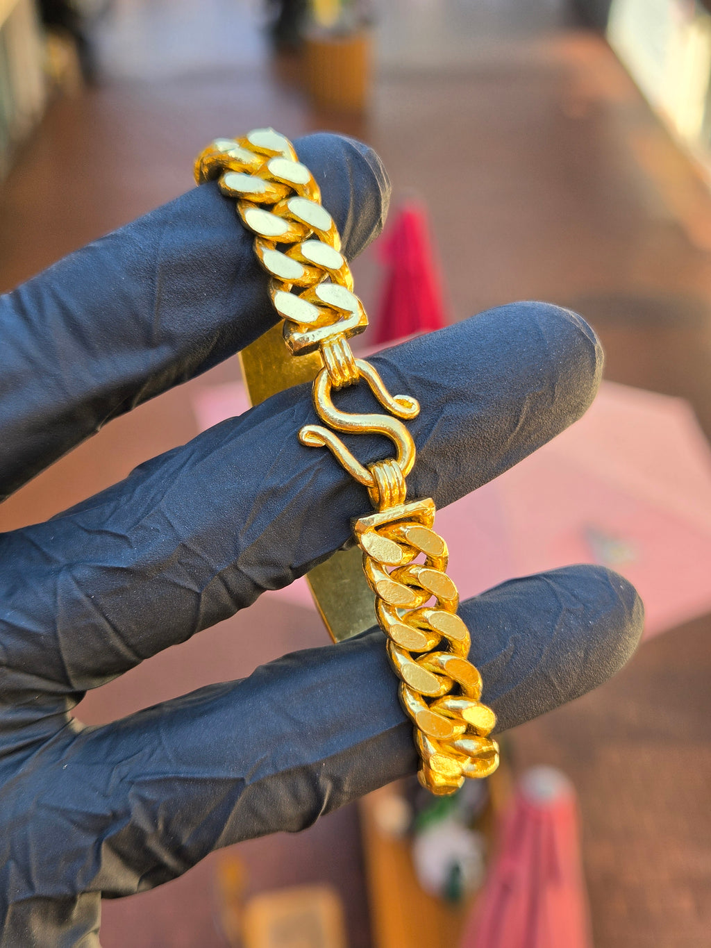 S-hook clasp of the 11MM engravable ID bracelet open against a gloved hand, showing the hook and eye