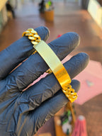The 11MM engravable ID bracelet laid across the fingers, its blank polished plate set into the Cuban link