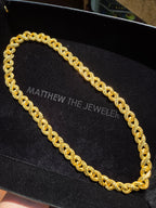 Diamond-Cut Infinity Link Chain in solid gold, mirror-cut faces catching the light against the matte frosted texture between them