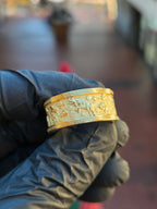 Goat Mural Ring in yellow gold, angled view of the 10MM band showing goats and stylized clouds in raised relief between Greek key borders