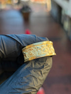 Goat Mural Ring in yellow gold, straight-on view centred on a leaping goat among clouds and blossoms on the frosted recessed field