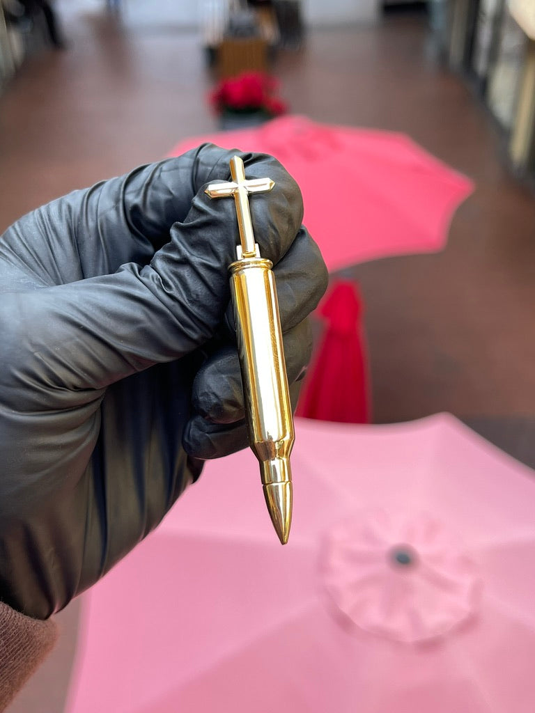 Solid gold .223 Remington rifle bullet pendant with a Latin cross rising from the case head, mirror-polished throughout
