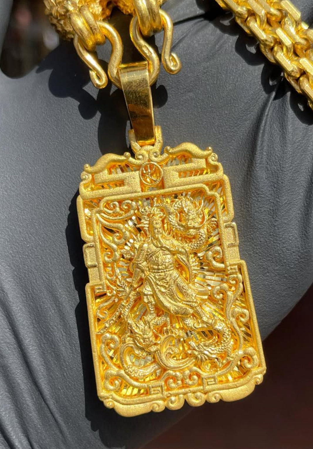Solid gold 3D Diamond-Cut God of War and Dragon Fretwork Pendant, pierced plaque with the armoured figure standing in front of a diamond-cut ray ground