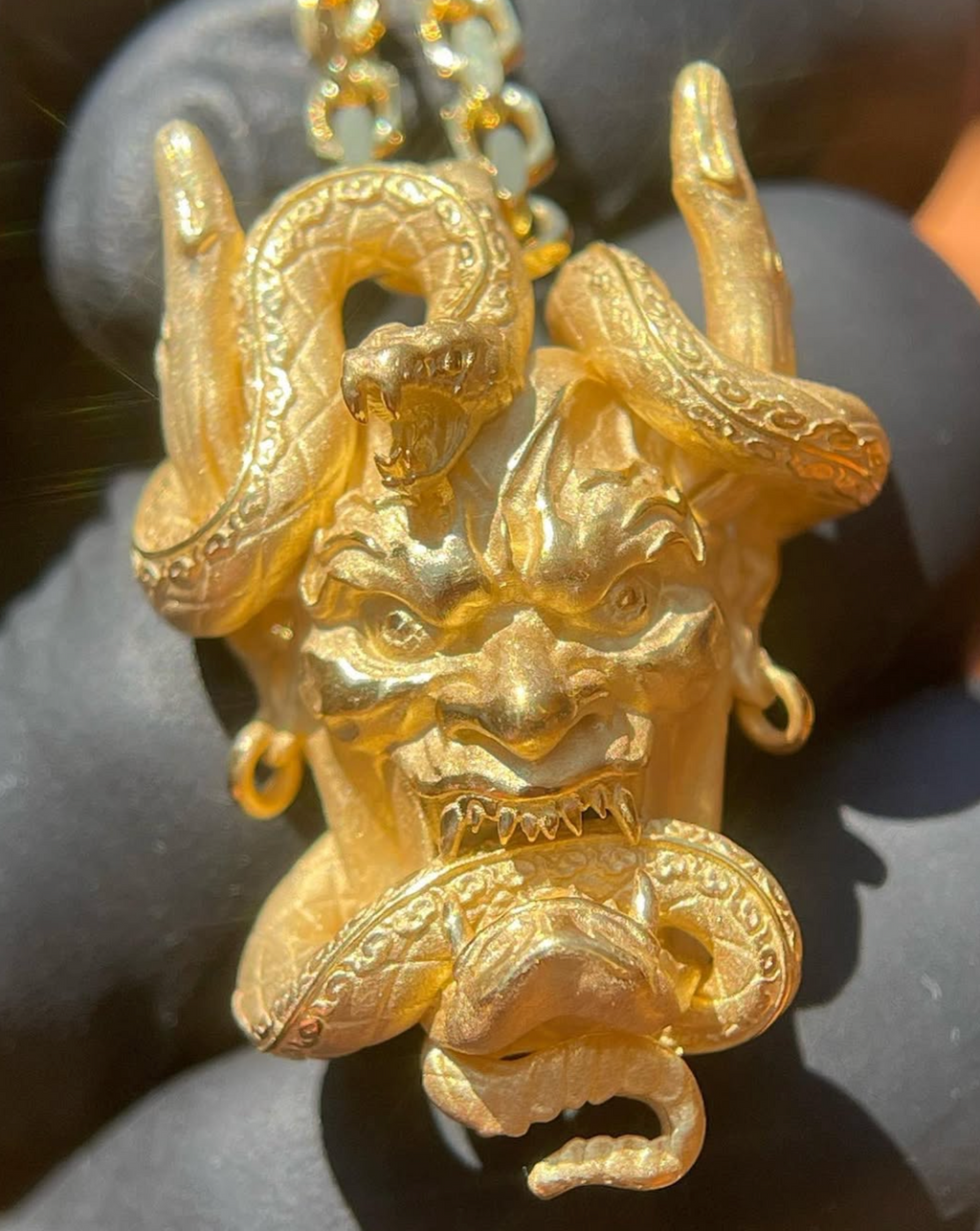 Gold Japanese Hannya mask pendant, horned Noh demon with a snake coiled through the horns