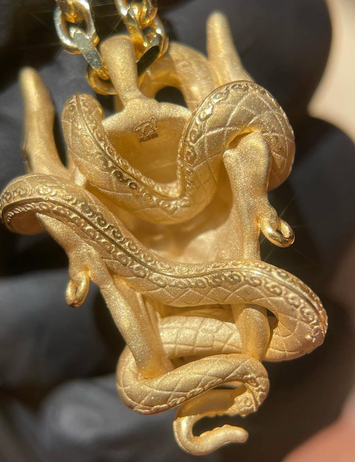 Hannya mask gold pendant reverse, snake coils continuing around the back with the hidden bail above