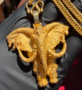 Gold decorated war elephant pendant, ears fanned wide with raised tusks and an ornamented headplate