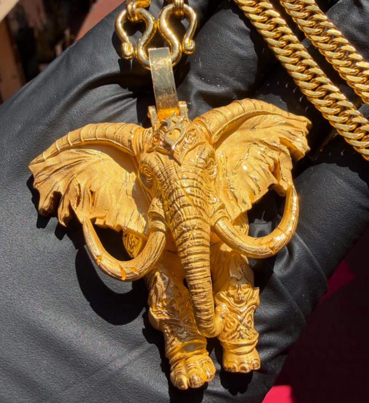 Gold decorated war elephant pendant, ears fanned wide with raised tusks and an ornamented headplate