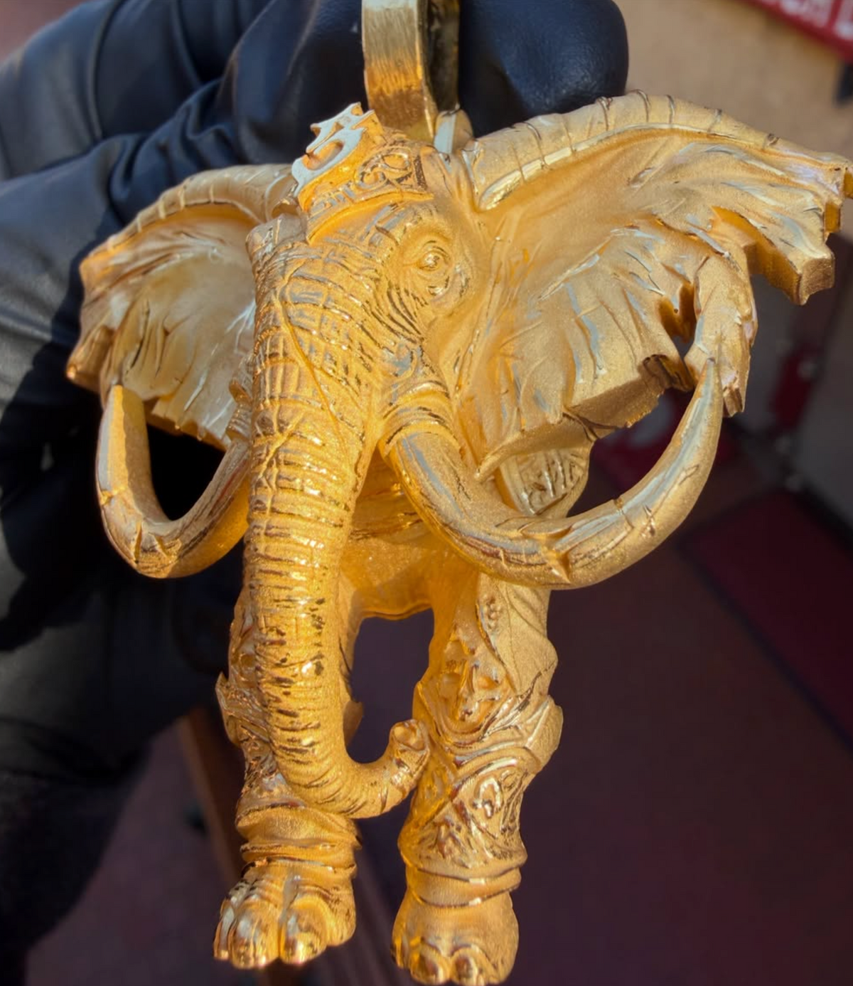 Decorated war elephant gold pendant, second view showing the veined ears and ringed trunk