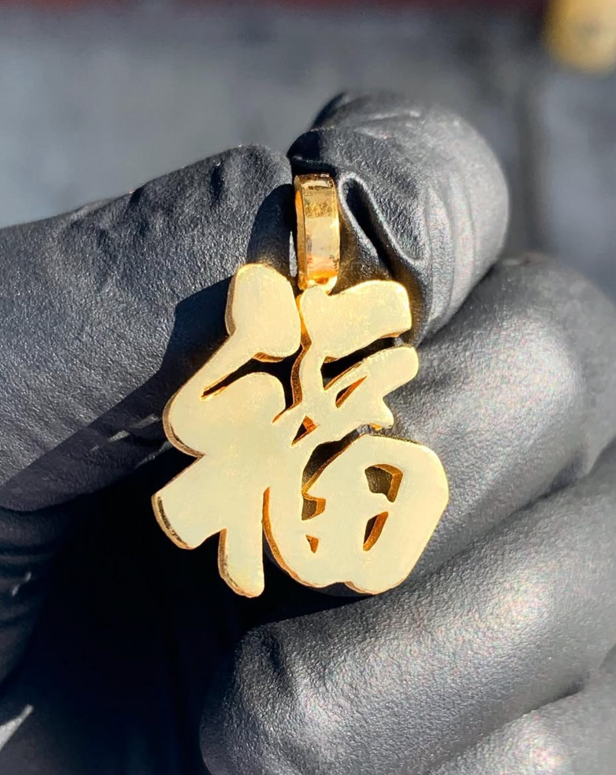 Solid gold Fu pendant, the Chinese character for good fortune cut as a free calligraphic silhouette