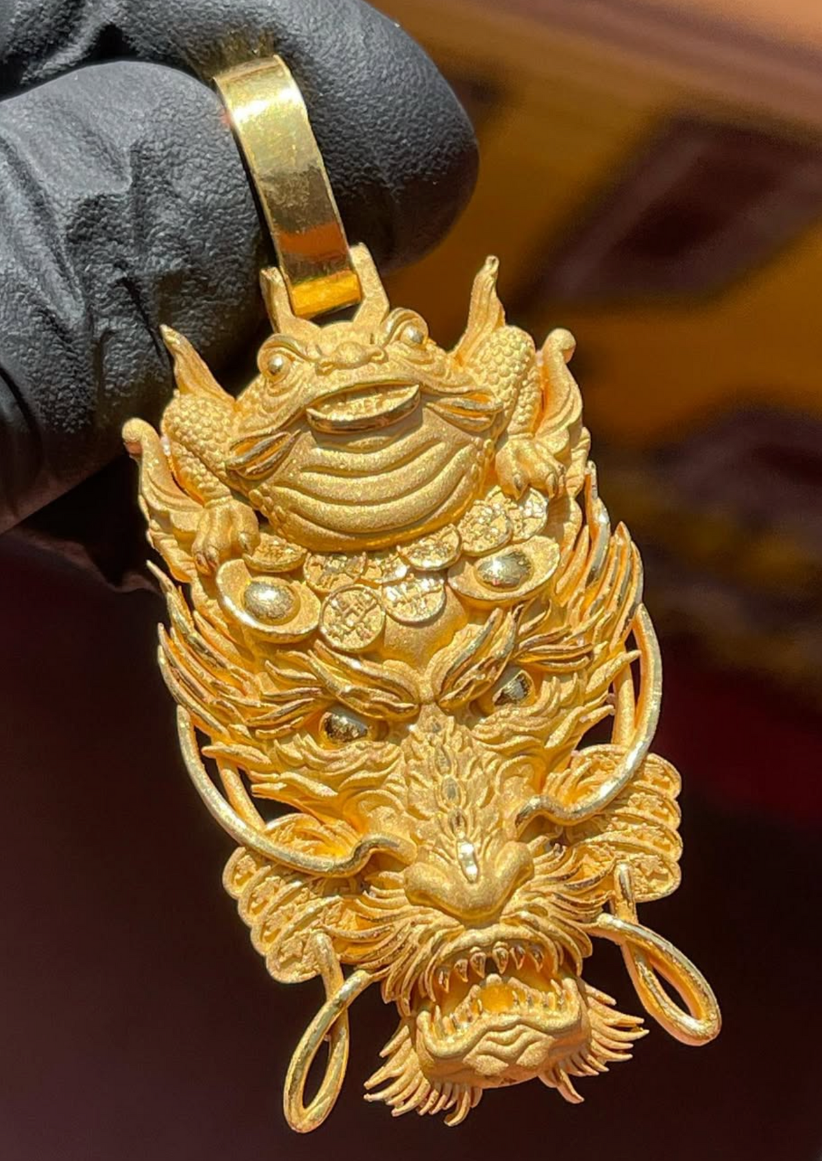 Gold money frog and dragon pendant, the three-legged toad above a dragon's head with coins and ingots between