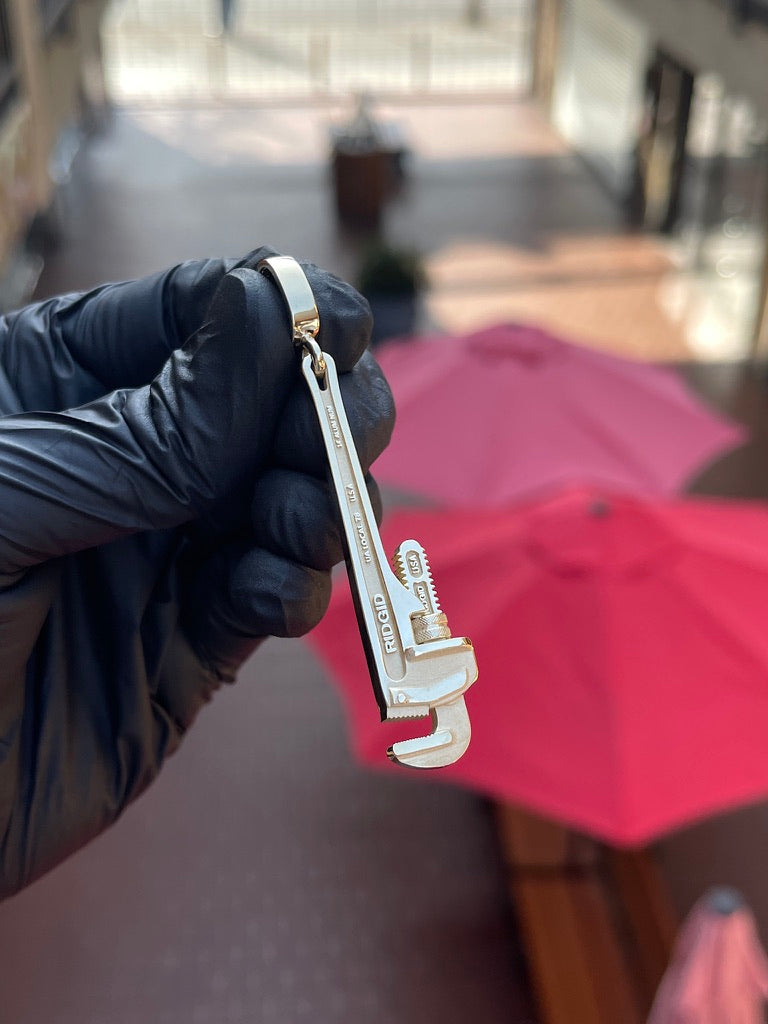 Solid gold pipe wrench pendant with toothed jaws, knurled adjusting nut and mirror-polished I-beam handle
