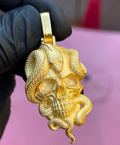 Gold skull and snake pendant, a snake coiled over the cranium with its head resting on the brow