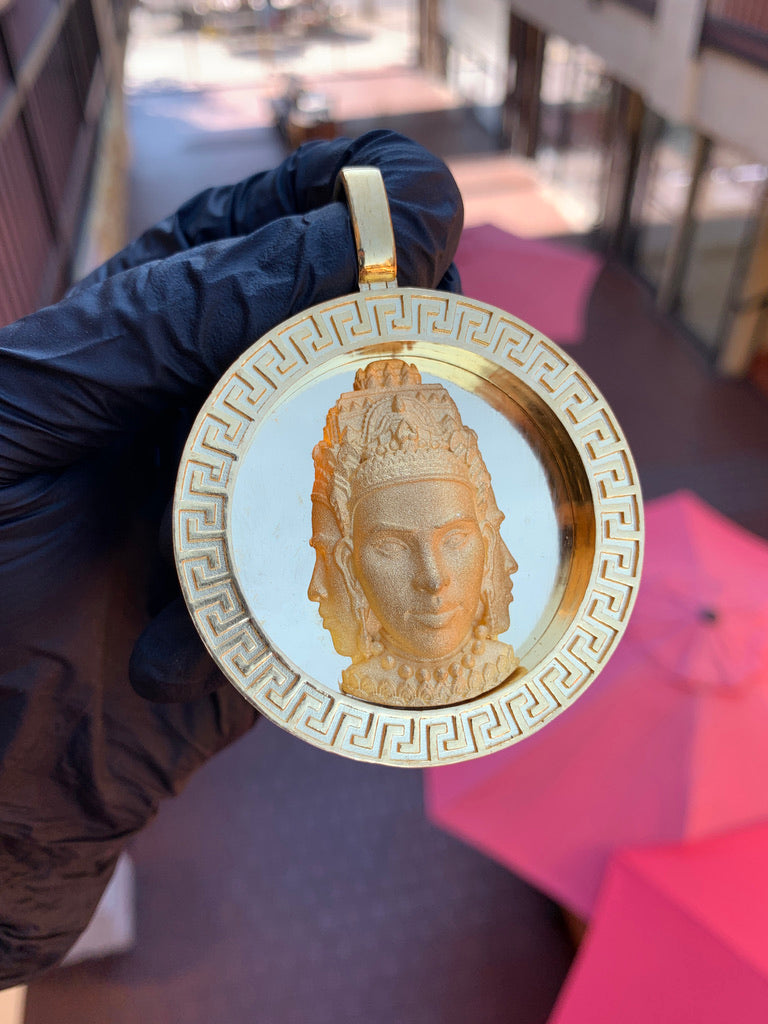 Solid gold three-headed Buddha circular pendant, crowned satin head in high relief inside a polished Greek key disc