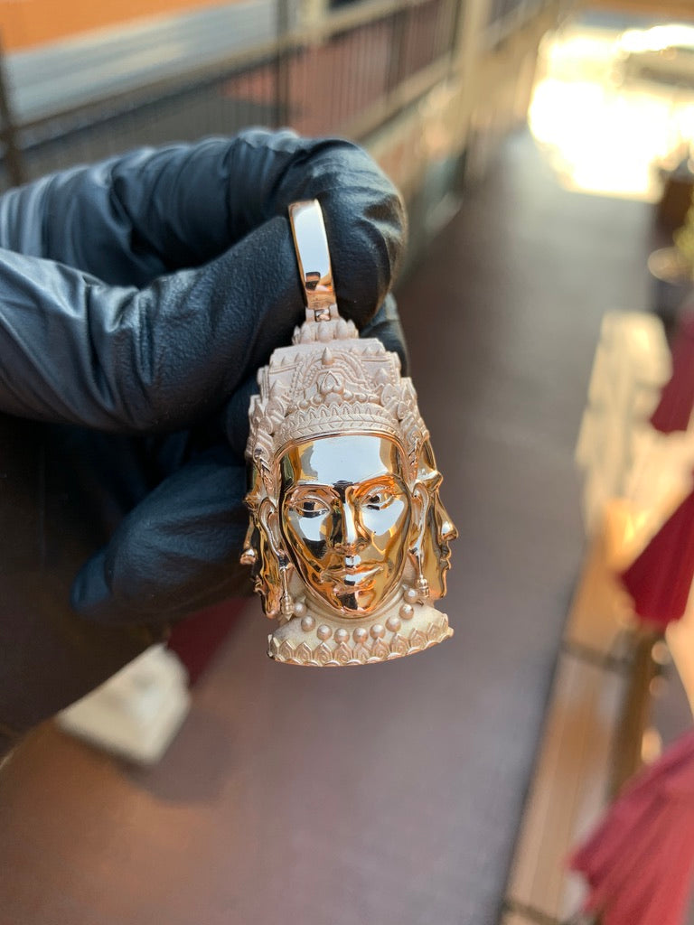 Solid gold three-headed Buddha pendant, mirror-polished faces against a satin tiered crown and beaded collar
