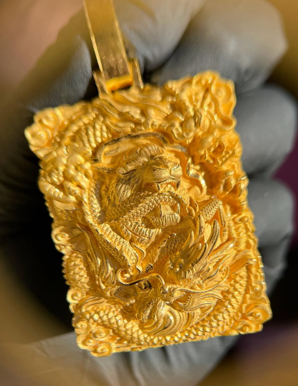 Tiger and Dragon Power gold pendant, close view of the dragon head and clawed foot