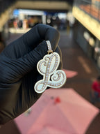 Cursive L diamond pendant, polished gold panel behind the pave script, with a pave-set bail