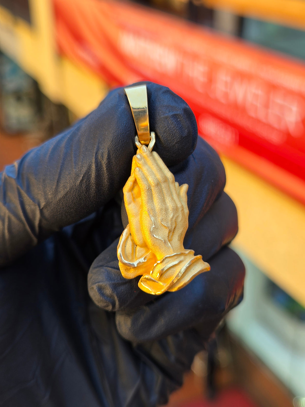 Detailed Praying Hands gold pendant, a free-cut sculpture with carved tendons, veins and nail beds in sandblasted matte