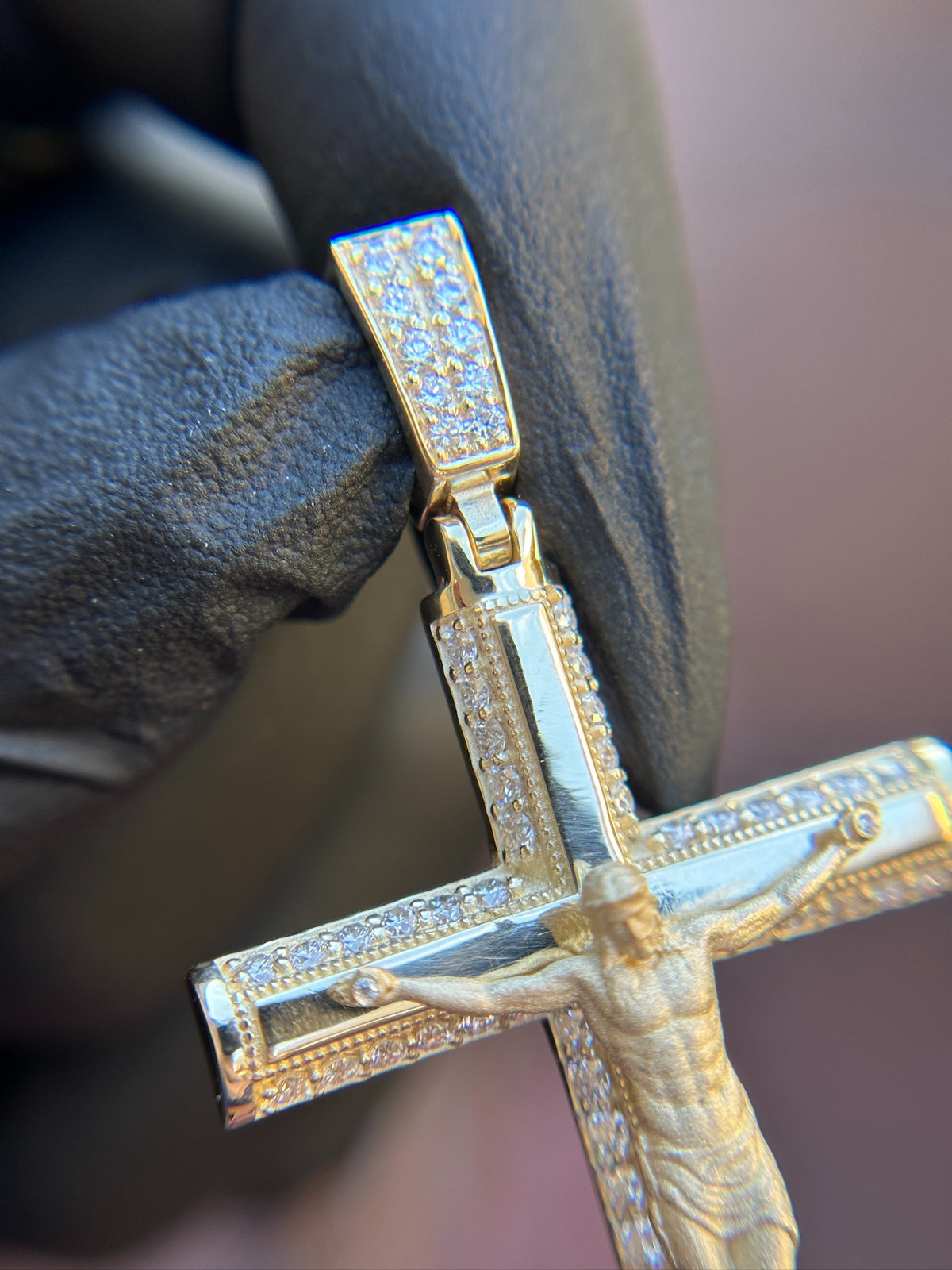Diamond crucifix pendant in gold, milgrain edging beside the pave diamond channels