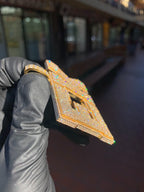 Angled view of the "EK" Diamond Pendant showing the stones carried over the top edge and the depth of the stepped border.