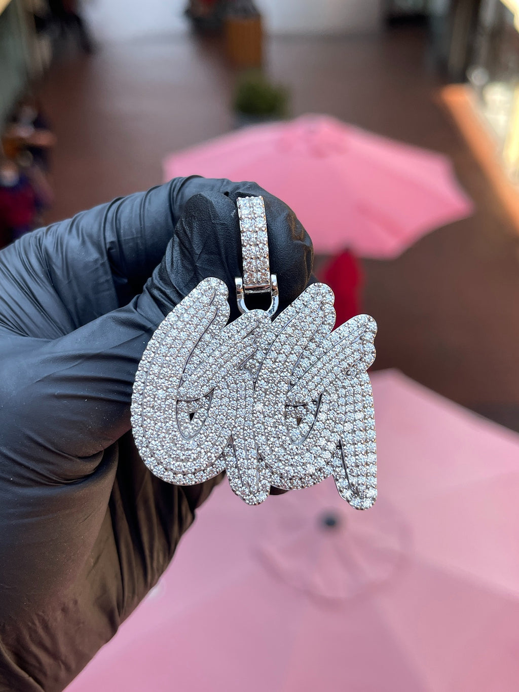Daylight view of the "GG" Diamond Pendant showing the swash tails crossing behind the second letter and the raised rim following the full outline.
