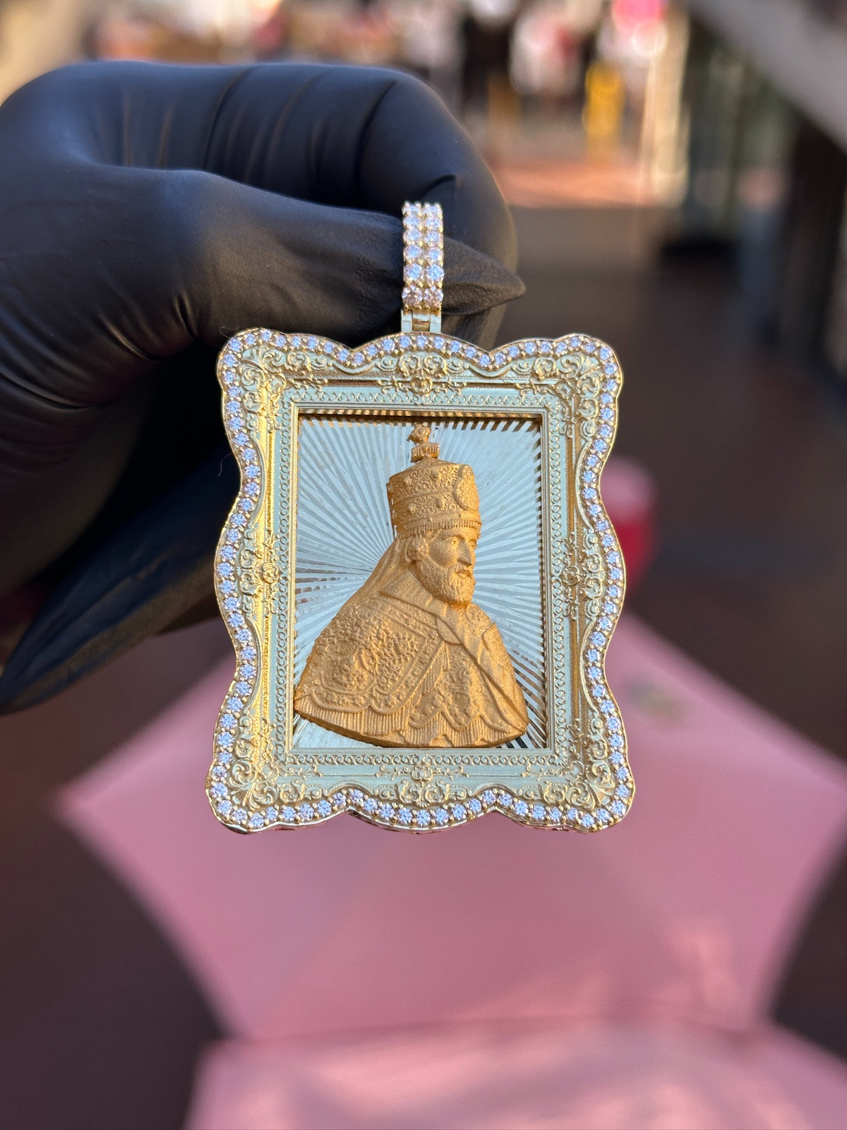 Haile Selassie diamond portrait pendant, scalloped diamond-set frame and engraved sunburst ground