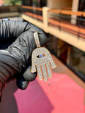 Yellow gold Hamsa Diamond Pendant, the open hand pave-set in round diamonds with concentric rows framing a marquise opening cut through the palm and a large round brilliant set as the pupil.
