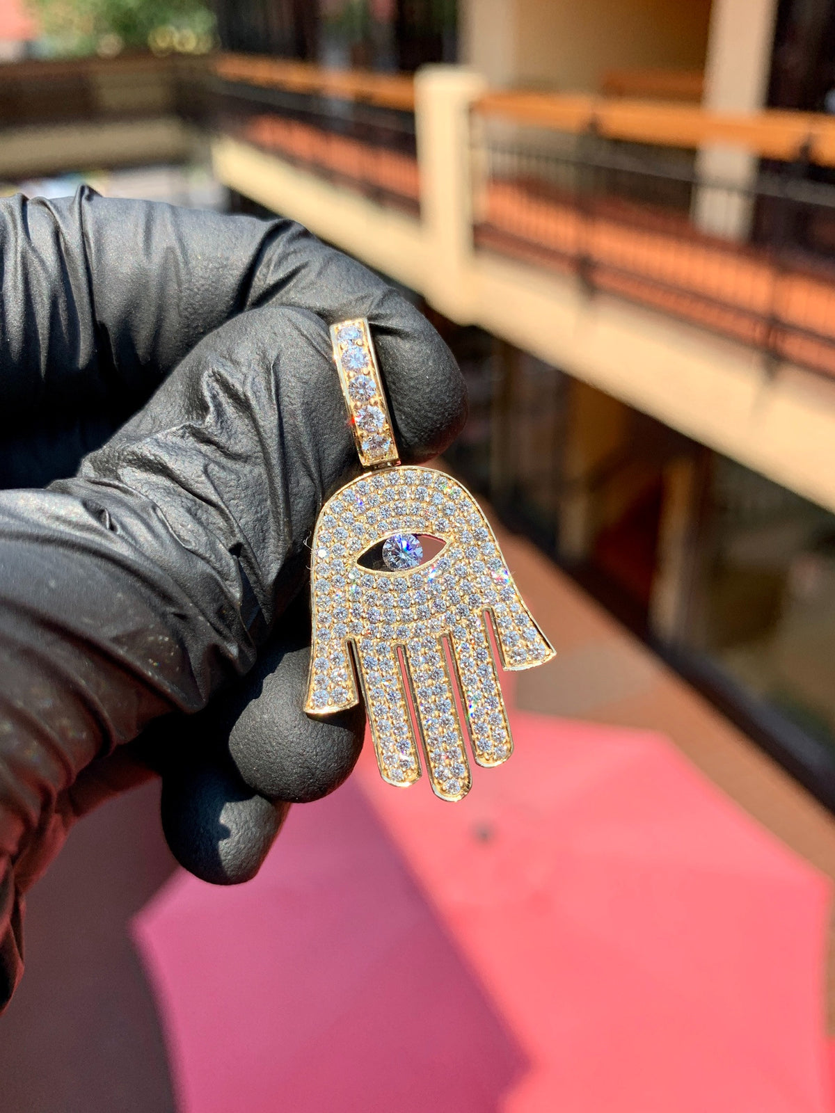 Yellow gold Hamsa Diamond Pendant, the open hand pave-set in round diamonds with concentric rows framing a marquise opening cut through the palm and a large round brilliant set as the pupil.