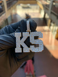 White gold "KS" Diamond Pendant, two block capitals fully pave-set in round diamonds with a raised polished rim around each letter and a pave bail.