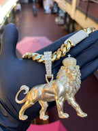 Daylight view of the Large Lion Partial Diamond Pendant showing the sculpted body and legs in bare gold against the fully set mane and cross-topped crown.