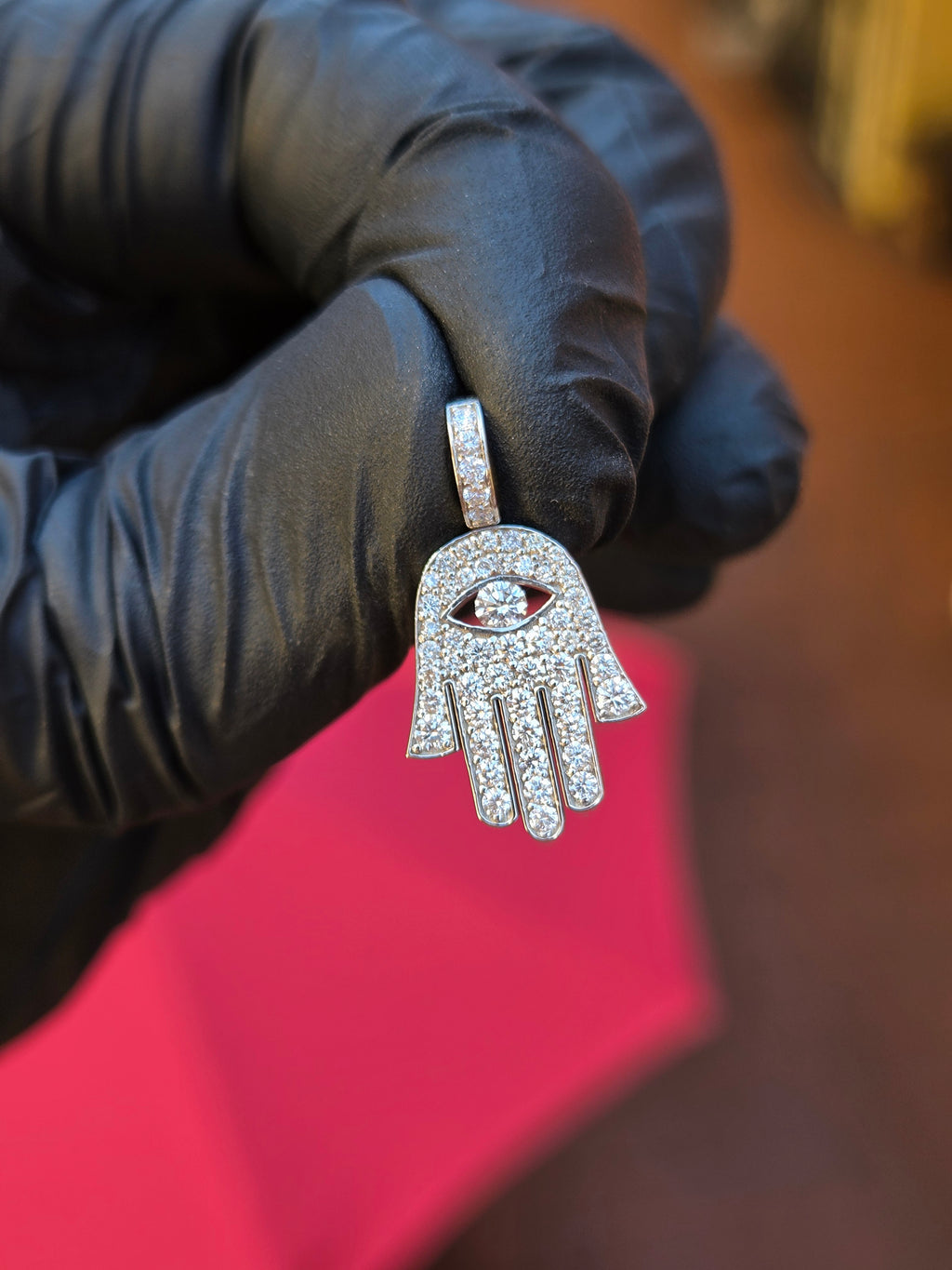 Mini Hamsa pendant showing the four fingers separated by slots cut right through, each its own run of stones