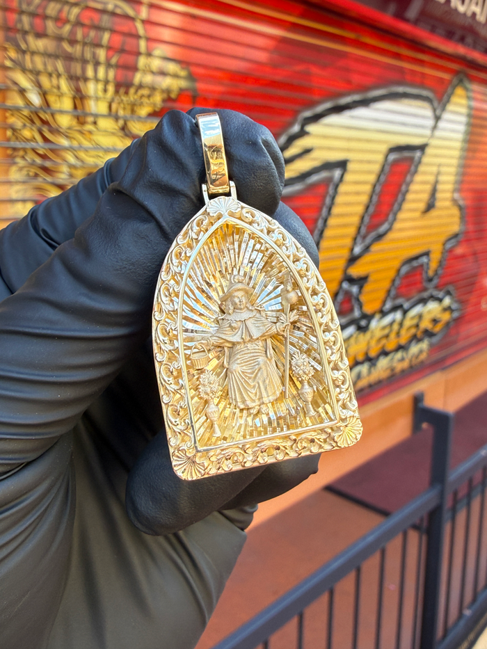 Holy Infant of Atocha gold pendant photographed in hand