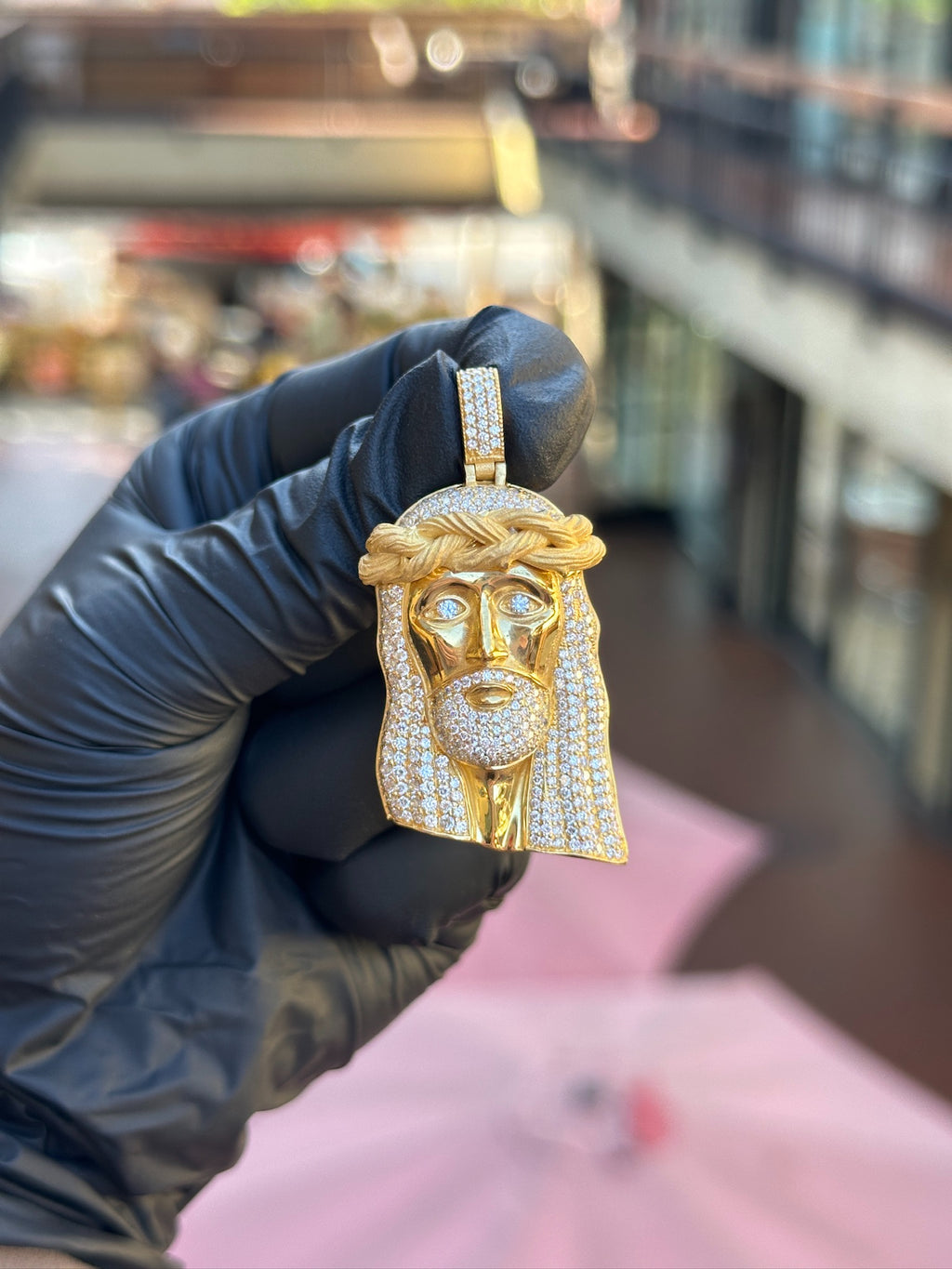 Partially iced Jesus head pendant, diamond-set eyes and pave hair against a plain polished face