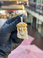 Partially iced Jesus head pendant, diamond-set eyes and pave hair against a plain polished face