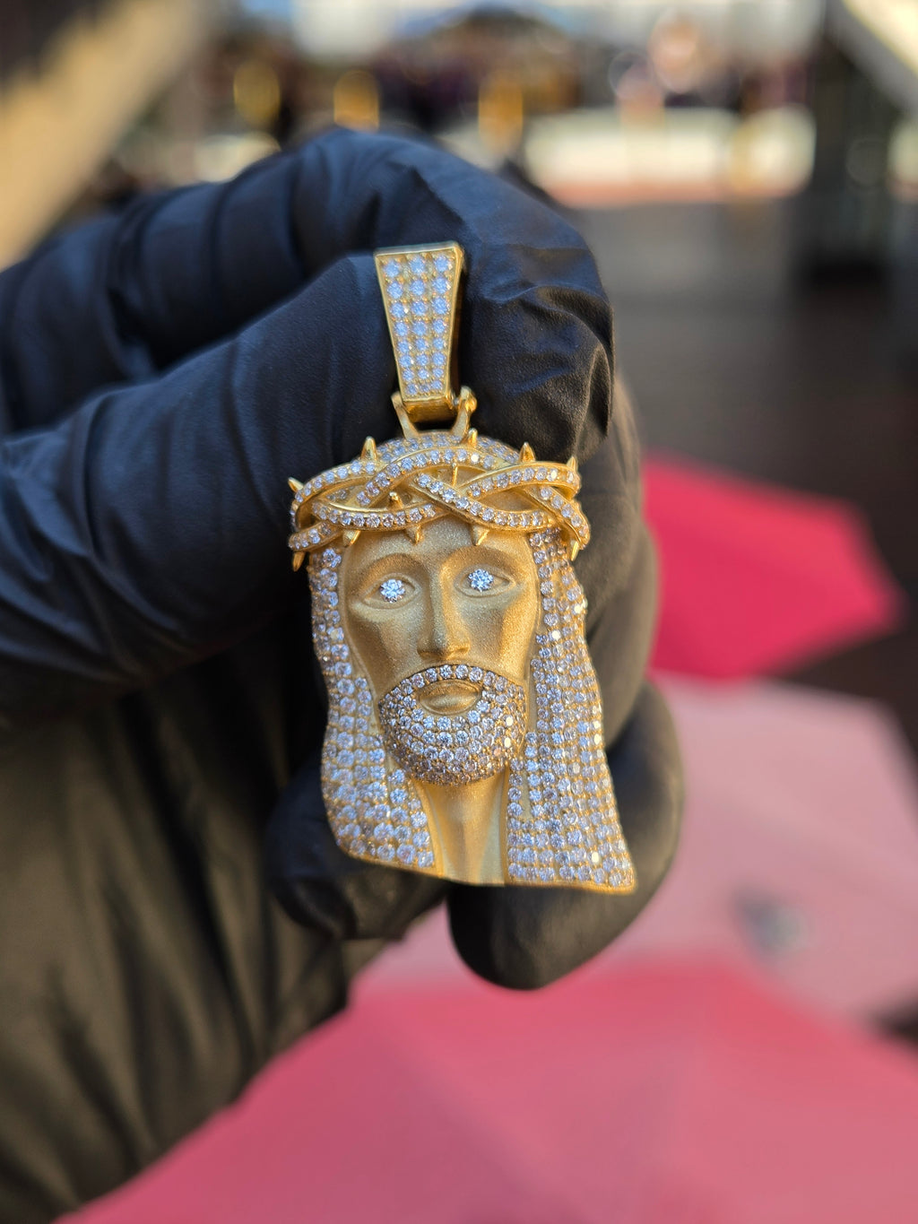 Jesus face pendant with a braided three-strand crown of thorns, pave strands and bare polished thorn points, and a diamond set in each eye