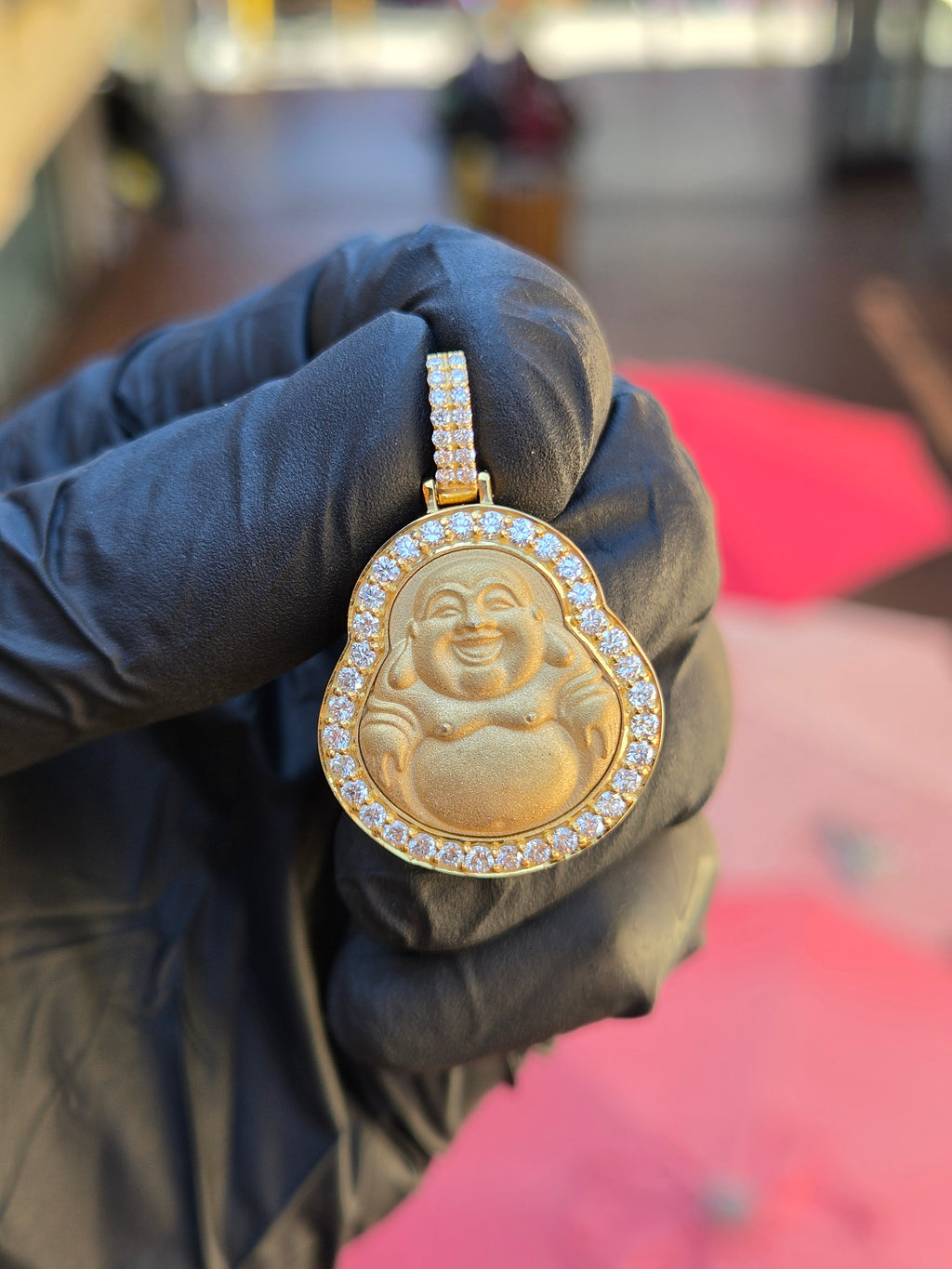 Small Happy Buddha diamond pendant in shade, showing the laughing figure's creased eyes and round belly against a polished frame