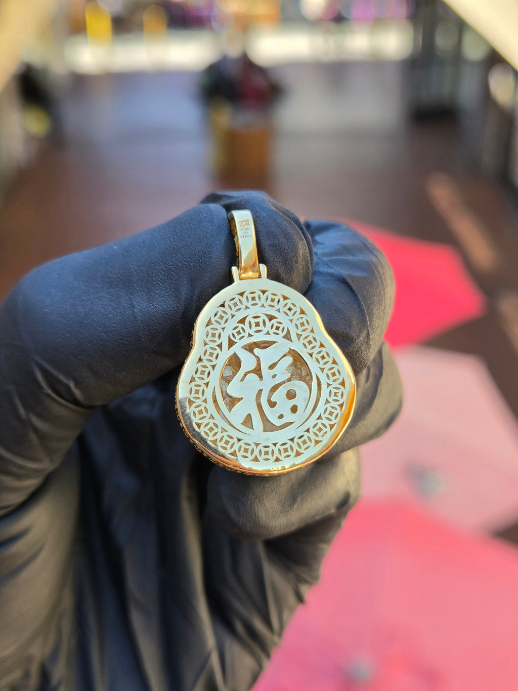 Openwork back of the Small Happy Buddha pendant, the fu character for fortune ringed by pierced Chinese cash coins