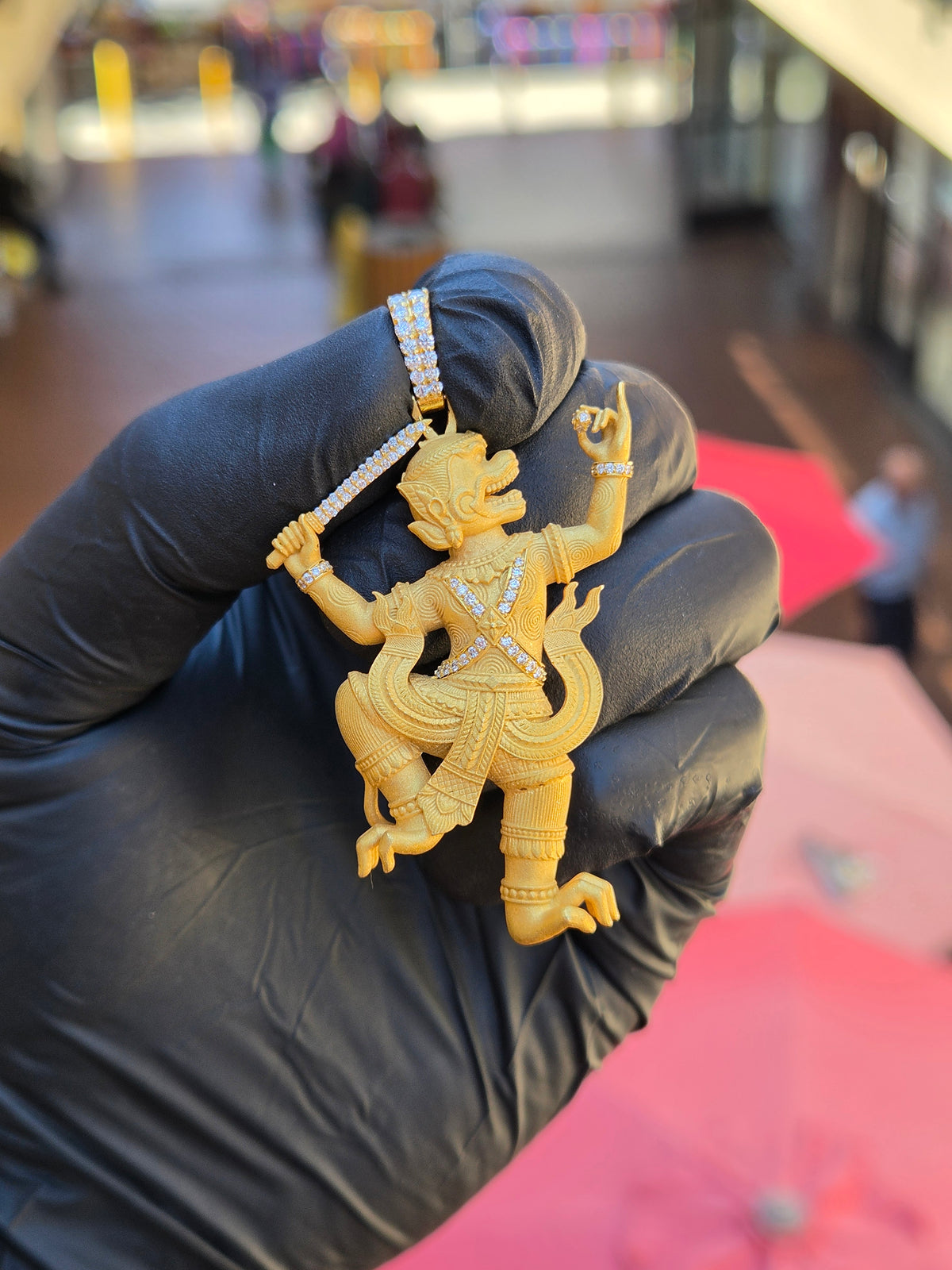 Thai Hanuman diamond pendant in daylight, pleated hip wrap and tiered collar in sandblasted gold with diamond cuffs at both wrists