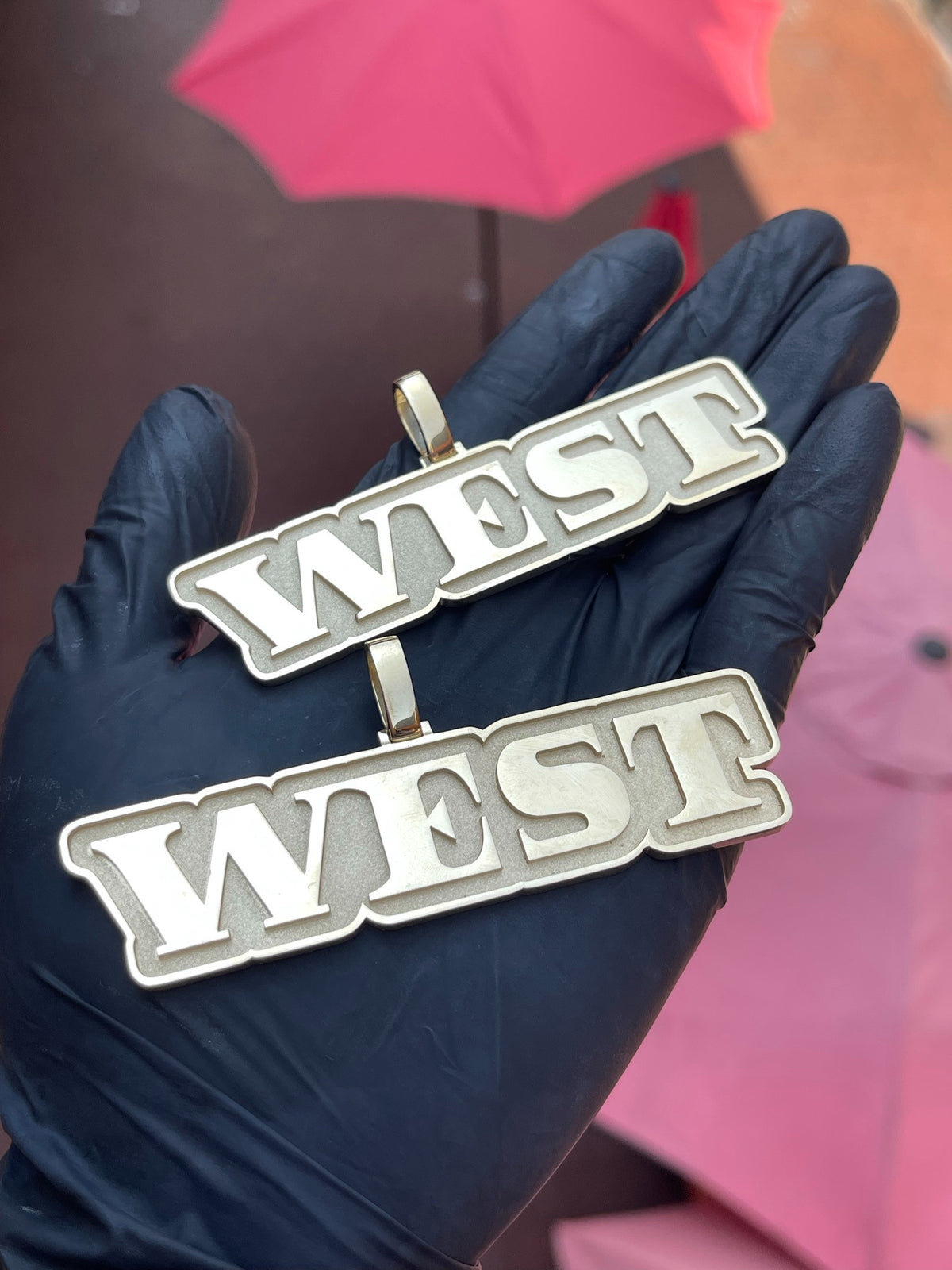 Two solid gold "West" Pendants in block capitals with a raised polished outline on a satin face. The picture shows two, but this listing is for one pendant.