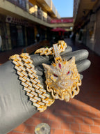 Daylight view of the Wolf Fully Diamond Pendant shown beside a Cuban link chain, with the snout tip, bared fangs and lower jaw left in bare satin gold. Chain not included.